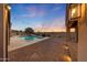 A backyard swimming pool with brick pavers and an open patio with string lights at 26204 S Washington St, Chandler, AZ 85249