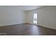 Empty bedroom features hardwood floors, white walls, natural light, and an entry door at 38065 N Cave Creek Rd # 2, Cave Creek, AZ 85331