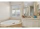 Bathroom with light-colored tub, vanity, and window with shutters at 3917 E Patrick Ln, Phoenix, AZ 85050