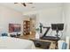 Bedroom with workout equipment and television; light-colored walls and tiled floor at 3917 E Patrick Ln, Phoenix, AZ 85050