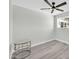 Minimalist bedroom featuring gray-toned walls, wood-look floors, and a dark ceiling fan at 5236 S 19Th Ave, Phoenix, AZ 85041