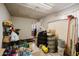 Cluttered basement featuring tiled flooring, storage shelves, and various household items at 5637 N 63Rd Dr, Glendale, AZ 85301