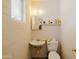 Small half bath featuring a toilet, sink, mirror, and a small window at 5637 N 63Rd Dr, Glendale, AZ 85301