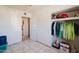 Clean bedroom featuring tile flooring and a closet with clothing and various household goods at 5637 N 63Rd Dr, Glendale, AZ 85301
