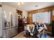 Open dining area featuring wood paneling, a ceiling fan, and a stainless steel refrigerator at 5637 N 63Rd Dr, Glendale, AZ 85301