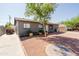 Home featuring gravel front yard and mature tree for shade in the desert landscape at 5637 N 63Rd Dr, Glendale, AZ 85301