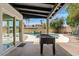 Covered backyard patio with foosball table near pool access through sliding glass doors at 5912 E Wethersfield Rd, Scottsdale, AZ 85254