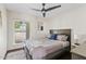 Comfortable bedroom boasts ceiling fan, large window, and a plush, inviting bed at 5912 E Wethersfield Rd, Scottsdale, AZ 85254