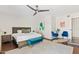 Bright main bedroom boasts ceiling fan, leafy wall art, and sitting area with stylish blue chairs at 5912 E Wethersfield Rd, Scottsdale, AZ 85254