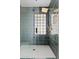 Modern tiled shower with glass block window, overhead shower head, and built-in shelving at 5912 E Wethersfield Rd, Scottsdale, AZ 85254