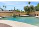 Sparkling swimming pool with water feature, surrounded by lush landscaping and mature palm trees at 5912 E Wethersfield Rd, Scottsdale, AZ 85254