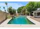 Large backyard swimming pool, lush trees, patio with outdoor dining and ample lounge seating at 5912 E Wethersfield Rd, Scottsdale, AZ 85254