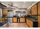 View of the bright kitchen with a large stainless steel refrigerator, wood cabinets, and stone tile flooring at 6306 N Camelback Manor Dr, Paradise Valley, AZ 85253