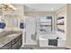 Bathroom features a glass block shower, a soaking tub, and a granite vanity with dual sinks at 6376 W Louise Dr, Glendale, AZ 85310