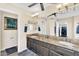 Bathroom with a double vanity, granite countertop, decorative mirrors, and neutral color palette at 6376 W Louise Dr, Glendale, AZ 85310