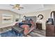 Cozy main bedroom features a tray ceiling, bench, and wood-look floors at 6376 W Louise Dr, Glendale, AZ 85310