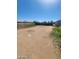 Expansive backyard featuring a dirt area, bordered by chain-link fencing and a clear blue sky at 6733 W Sherri Jean Ln, Peoria, AZ 85382