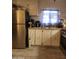 Charming kitchen featuring stainless steel refrigerator, white cabinetry, and tile floors at 6733 W Sherri Jean Ln, Peoria, AZ 85382