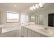 Bathroom features a dual sink vanity, soaking tub, and large window for plenty of natural light at 694 W Desert Seasons Dr, San Tan Valley, AZ 85143