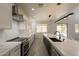 The kitchen boasts white cabinets, stainless steel appliances, island seating and marble countertops and backsplash with modern lighting at 694 W Desert Seasons Dr, San Tan Valley, AZ 85143