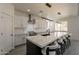 A kitchen boasts a large island with seating, modern lighting, stainless steel appliances, and white marble countertops and backsplash at 694 W Desert Seasons Dr, San Tan Valley, AZ 85143