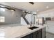 A kitchen opens into a large living space featuring an island with seating, stainless steel appliances, and modern light fixtures at 694 W Desert Seasons Dr, San Tan Valley, AZ 85143