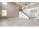 A large living space features a staircase with iron railings, a gray accent wall, tile flooring, and plenty of natural light at 694 W Desert Seasons Dr, San Tan Valley, AZ 85143