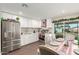 Modern kitchen with white cabinetry, stainless steel appliances, and an adjacent dining area, perfect for entertaining at 7502 W Cora Ln, Phoenix, AZ 85033