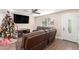 Relaxing living room with a large leather sectional, a ceiling fan, and natural light, perfect for Gathering time at 7502 W Cora Ln, Phoenix, AZ 85033