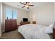 A bedroom features neutral paint, carpet, ceiling fan, and a wooden dresser at 7939 W Fetlock Trl, Peoria, AZ 85383