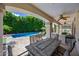 Inviting covered patio features an outdoor dining set with a view of the sparkling pool and lush backyard at 7939 W Fetlock Trl, Peoria, AZ 85383