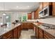 This kitchen features brown cabinets, granite countertops, stainless steel appliances, and tiled floors at 7939 W Fetlock Trl, Peoria, AZ 85383