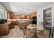 This kitchen features brown cabinets, granite countertops, stainless steel appliances, tile flooring, and a dining table at 7939 W Fetlock Trl, Peoria, AZ 85383