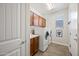 Laundry room with upper cabinets, a utility sink, a window for natural light, and modern washer and dryer at 7939 W Fetlock Trl, Peoria, AZ 85383