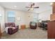 A living room or office space features neutral paint, carpet, and a ceiling fan at 7939 W Fetlock Trl, Peoria, AZ 85383