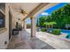 Covered patio with ceiling fans overlooks a pool, landscaping, and outdoor seating, perfect for entertaining at 7939 W Fetlock Trl, Peoria, AZ 85383