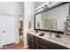Bathroom featuring double sinks with granite counters, black fixtures, and a view to the shower at 9545 E Gary St, Mesa, AZ 85207