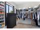 Large walk-in closet featuring custom shelving, hanging racks, and a dark wood dresser with natural light at 9545 E Gary St, Mesa, AZ 85207