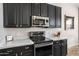 Modern kitchen featuring stainless steel appliances and sleek, black cabinetry at 9545 E Gary St, Mesa, AZ 85207