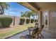 Back patio with table and chairs, enclosed by a block wall and view of green grass at 11360 E Keats Ave # 20, Mesa, AZ 85209