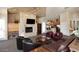 A spacious living room with a fireplace, TV and leather furniture at 11375 E Sahuaro Dr # 2064, Scottsdale, AZ 85259