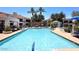 A long community pool features a fountain, palm trees, lounge chairs and outdoor furniture at 11375 E Sahuaro Dr # 2064, Scottsdale, AZ 85259