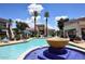 A community pool features a fountain, palm trees, lounge chairs and outdoor furniture at 11375 E Sahuaro Dr # 2064, Scottsdale, AZ 85259