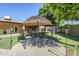 Charming backyard with a seating area under a tiki umbrella, perfect for enjoying the outdoors at 12434 S Ki Cir, Phoenix, AZ 85044