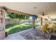 View of the outdoor backyard and a covered patio with yellow chairs and flat-screen TV at 12434 S Ki Cir, Phoenix, AZ 85044