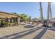 Expansive backyard with a covered patio, multiple seating areas, mature palm trees, and well-manicured landscaping at 12434 S Ki Cir, Phoenix, AZ 85044