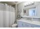 Charming bathroom with marble countertop vanity, white shower curtain and an elegant, framed mirror at 12434 S Ki Cir, Phoenix, AZ 85044