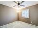Simple bedroom with wall-to-wall carpeting, ceiling fan, and plantation shutters at 12434 S Ki Cir, Phoenix, AZ 85044