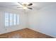 Bright, airy bedroom featuring tile floors, plantation shutters, and ceiling fan at 12434 S Ki Cir, Phoenix, AZ 85044