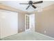 Basic bedroom features sliding closet doors, a ceiling fan, and doorway to the en suite bathroom at 12434 S Ki Cir, Phoenix, AZ 85044